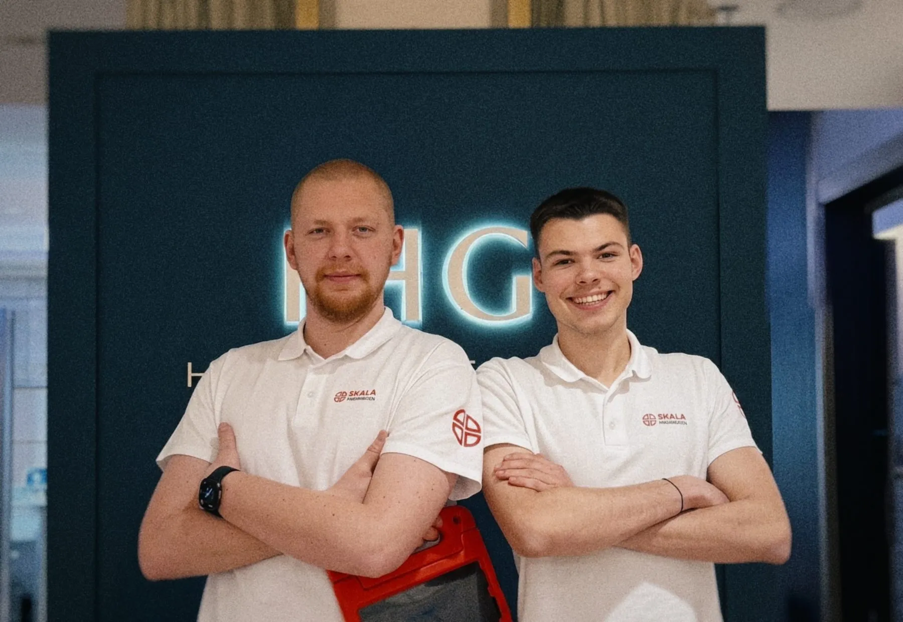 Zwei Sanitäter von SKALA Paramedics lächelnd am Eingang einer Veranstaltung