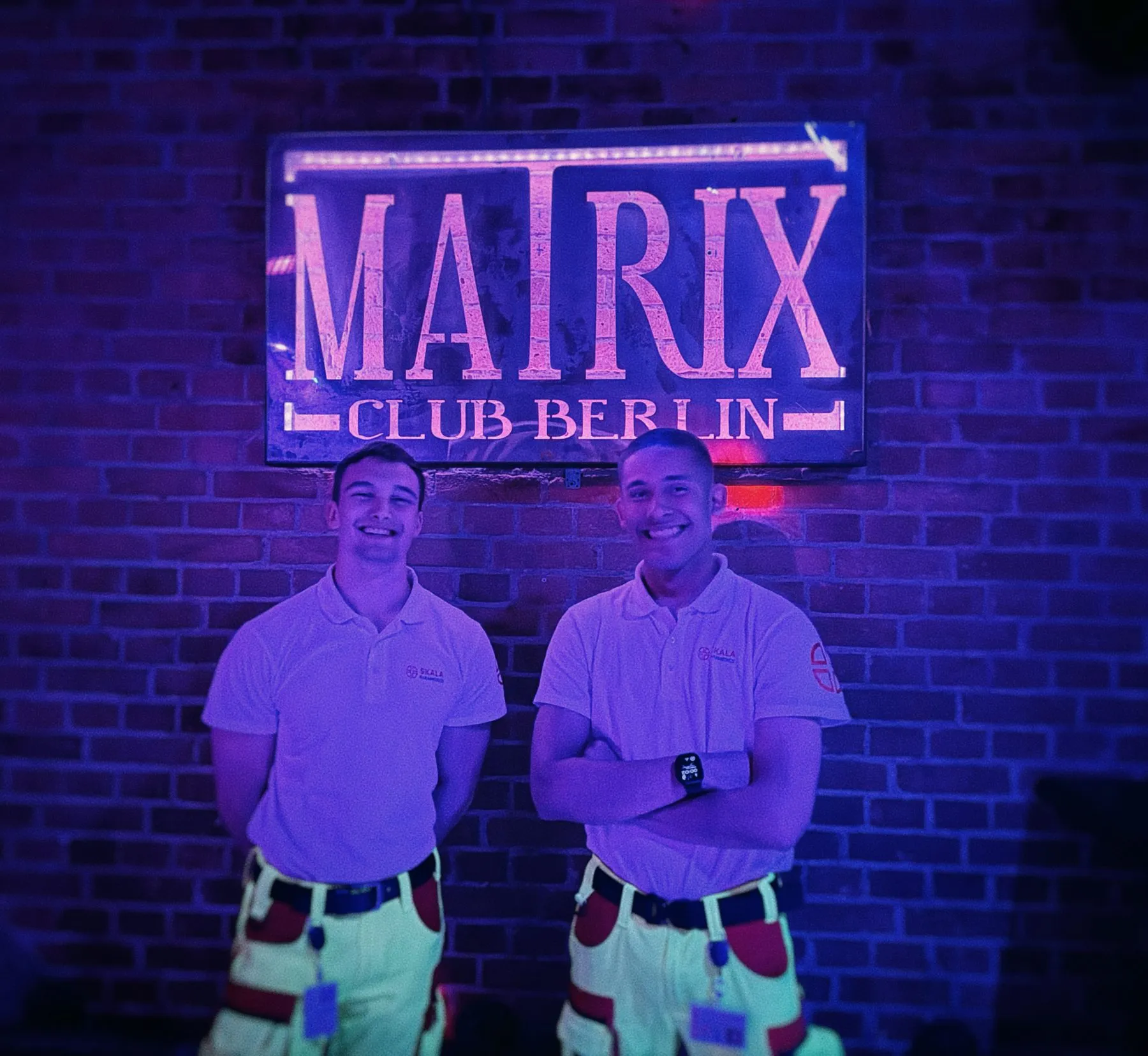 Zwei Sanitäter von SKALA Paramedics vor dem Leuchtschild des Matrix Club Berlin