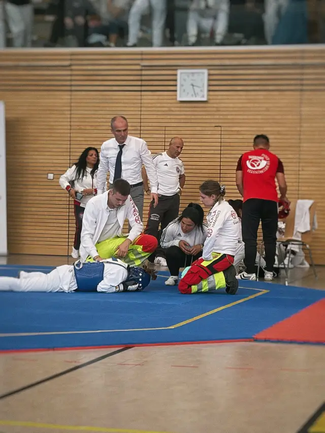 Sanitäter von SKALA Paramedics versorgen einen Sportler auf der Matte bei einem Taekwondo-Turnier