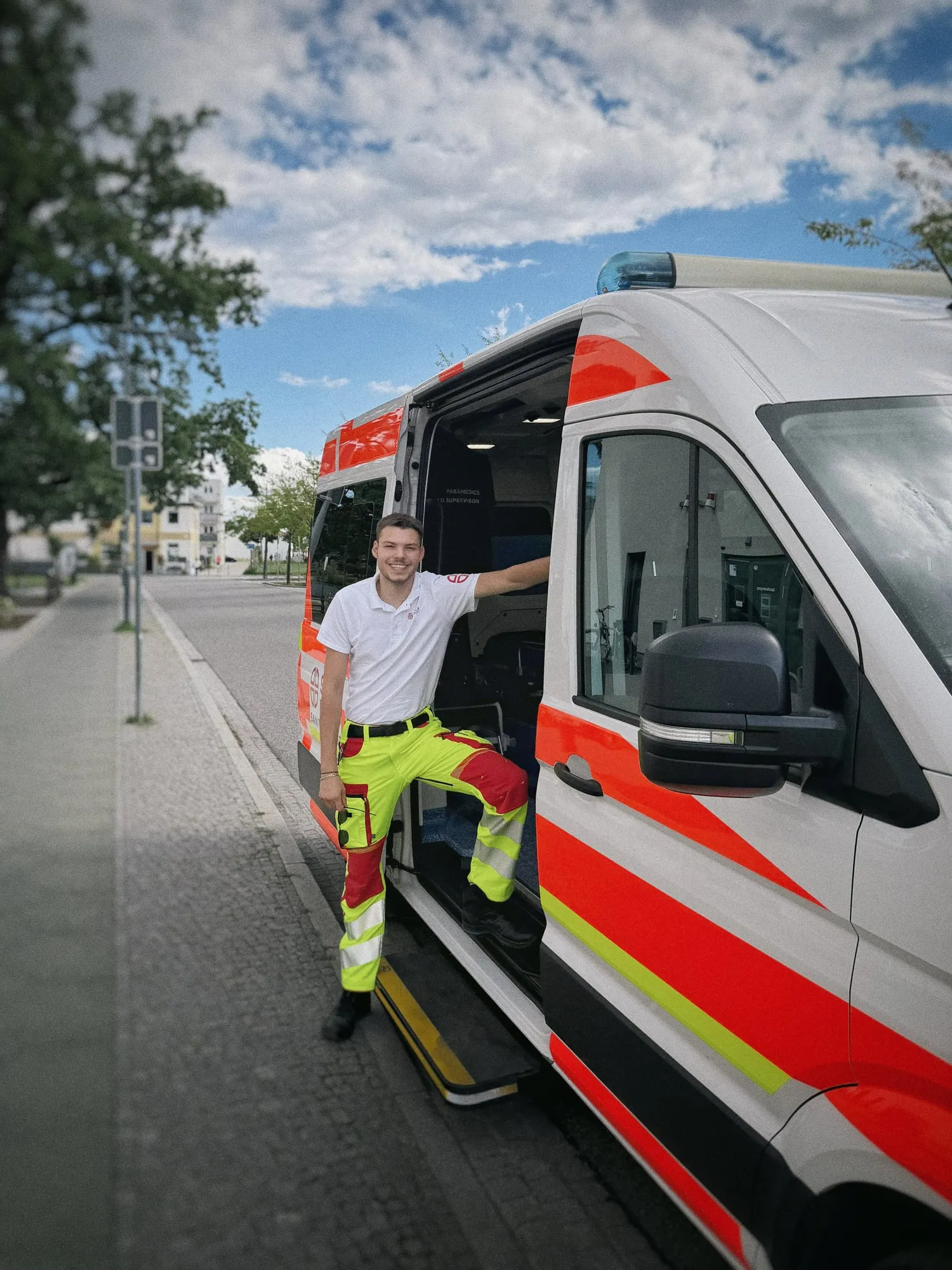 Sanitäter von SKALA Paramedics steht in der offenen Seitentür des Krankentransportwagens