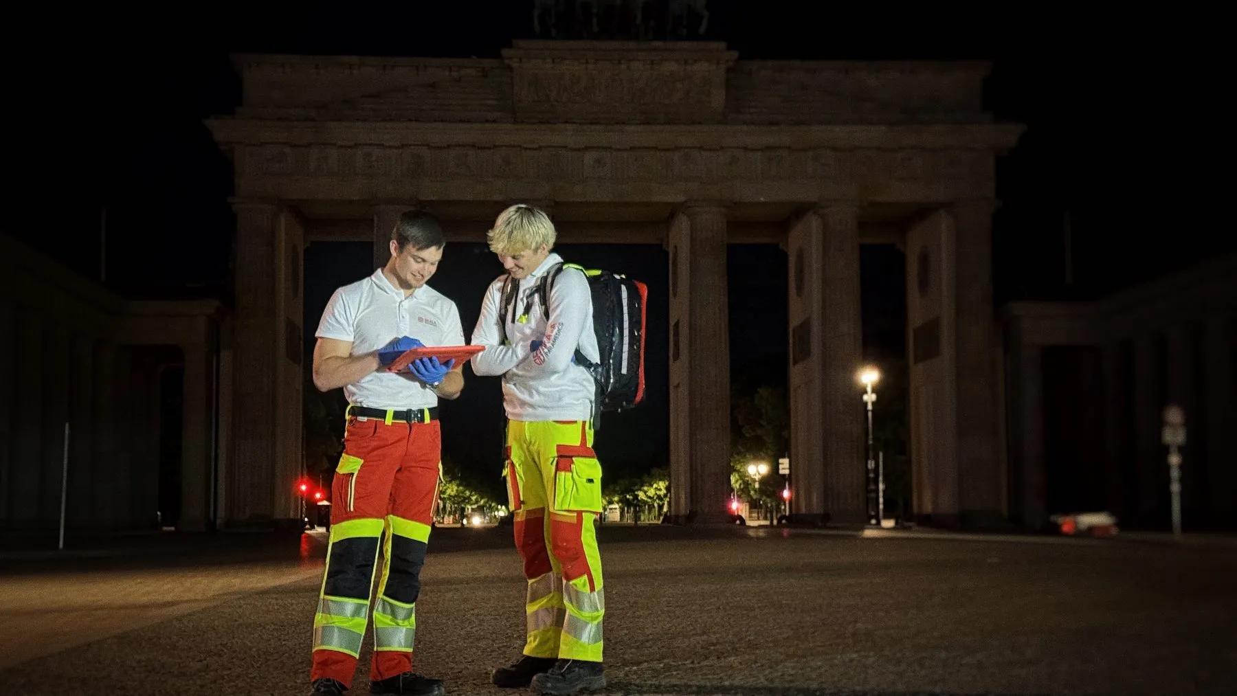 Zwei Sanitäter in SKALA-Einsatzkleidung nachts vor dem Brandenburger Tor