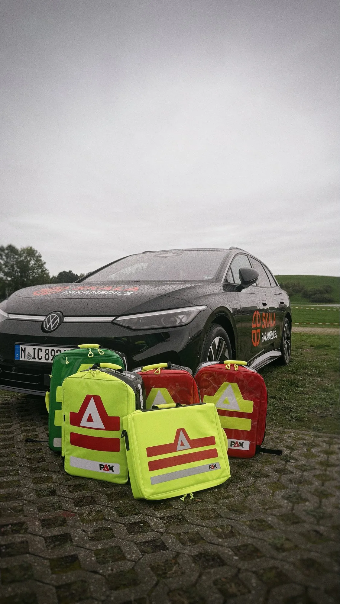 Mehrere Notfallrucksäcke vor dem schwarzen Supervisor-Fahrzeug von SKALA