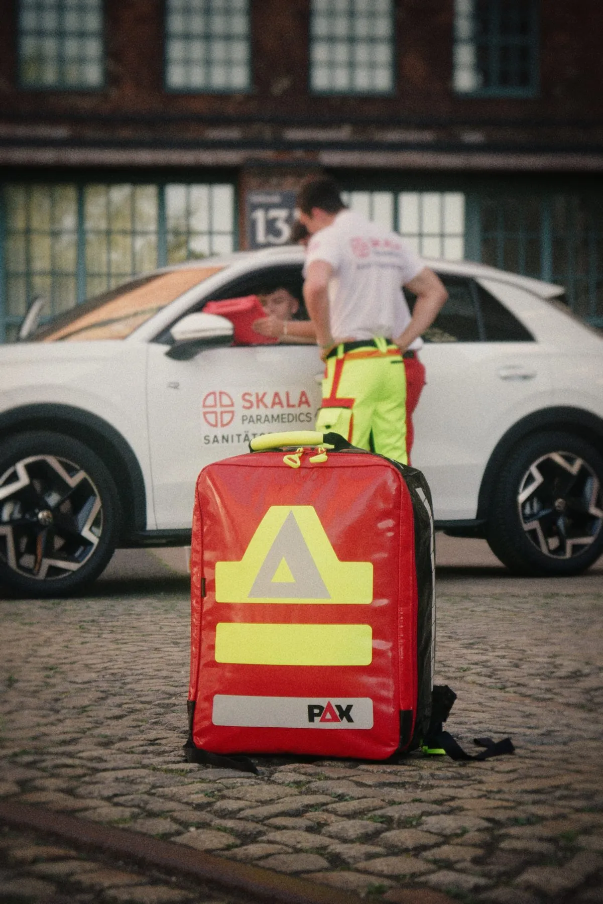 Roter Notfallrucksack vor dem SKALA-Einsatzfahrzeug